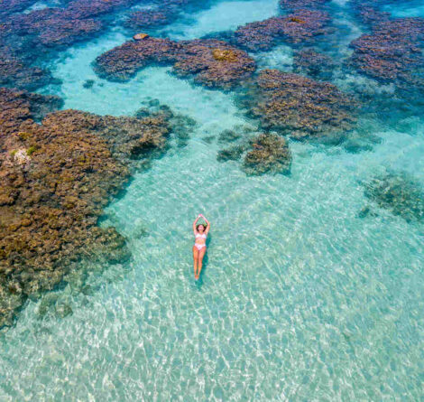 Vista aérea de mulher nadando em uma das praias de Maceió.