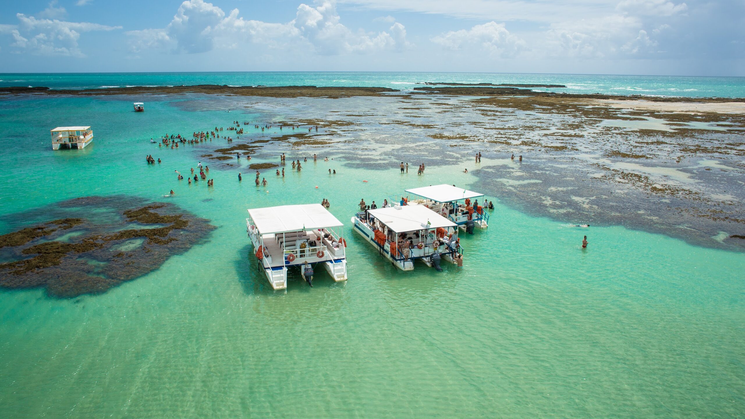 Barcos de passeio as piscinas naturais da praia de Barra Grande, as Galés de Maragogi.