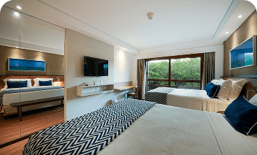 apartamento superior Quarto Apartamento Superior no Salinas Maceió destacando a vista externa pra o jardim e coqueiros próximos à área de lazer.