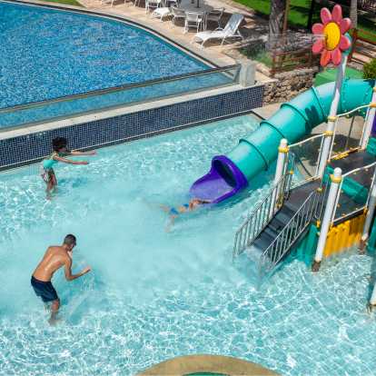 caiaque no rio Família se divertindo na piscina do Salinas Maceió. A filha esta descendo do toboágua, enquanto os pais jogam água pra cima.