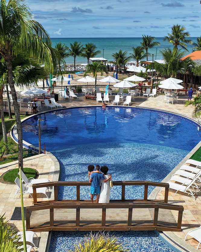 vista aerea das piscinas do salinas-maceió Família sobre ponte da piscina do Salinas Maceió, aprecisando à vista pro mar da praia de Ipioca, onde está localizado o resort.