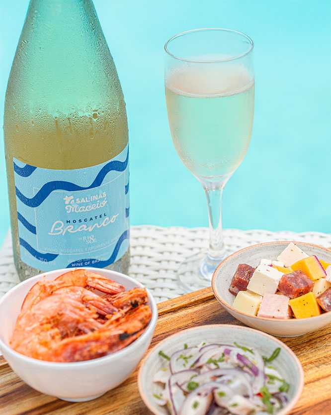 resort all inclusive praia Petiscos variados ( camarão, ceviche, queijos) e moscatel branco personalizado do Salinas Maceió, sobre tábuas de madeira na beira de uma piscina do resort.
