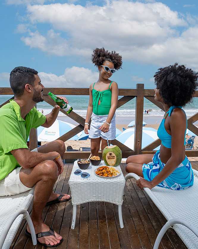 vista aerea piscinas naturais pajucara Família desfruta petiscos no deck do Salinas Maceió, com a praia de Ipioca ao fundo.