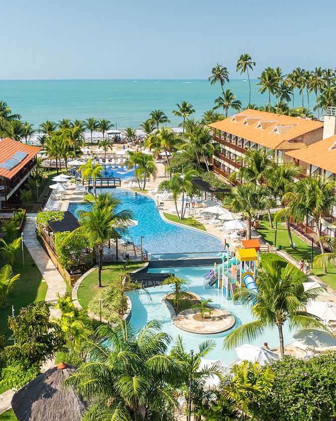 resort de praia Vista aérea do resort Salinas Maceió. A área de lazer tem piscinas interligadas, coqueiros e escorregadores. Ao fundo, a praia com o mar azul-turquesa