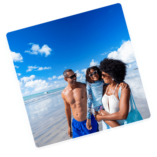 família caminhando na beira mar de Alagoas Pai, mãe e filha caminhando na beira mar de Alagoas com o oceano e um céu azul ao fundo.