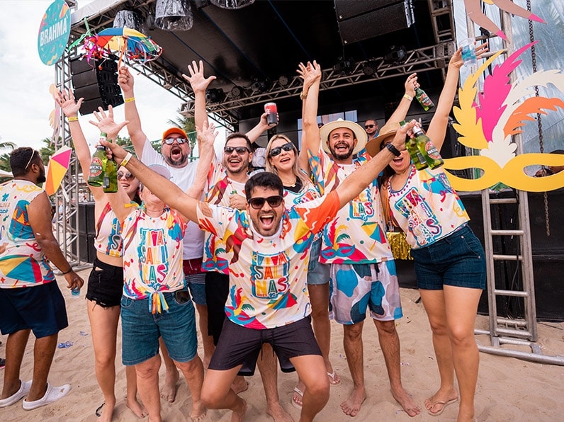 Amigos curtem o carnaval Salinas Maceió com abadá do bloco em frente ao palco.