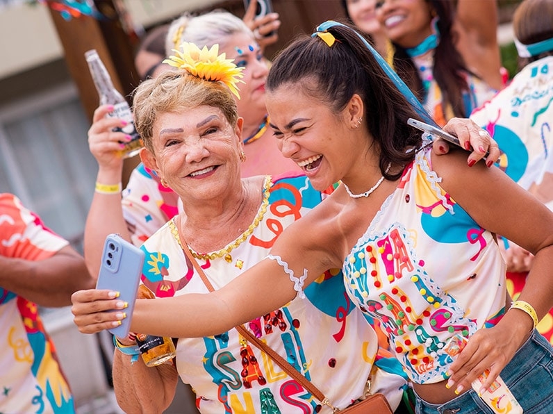 Mulheres vestidas com abadá do Carnaval Salinas Maceió posam pra foto
