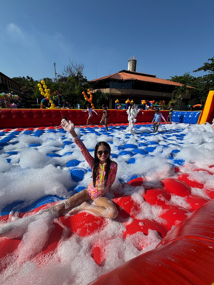 Crianças se divertindo em atividade recreativa com espuma no Salinas Maceió, em espaço ao ar livre com programação infantil durante o dia das crianças.