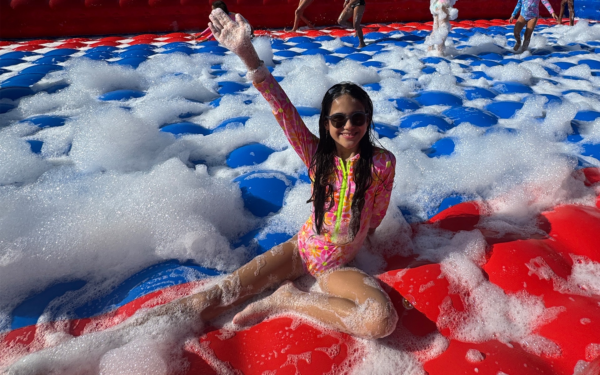 Crianças se divertindo em atividade recreativa com espuma no Salinas Maceió, em espaço ao ar livre com programação infantil durante o dia das crianças.