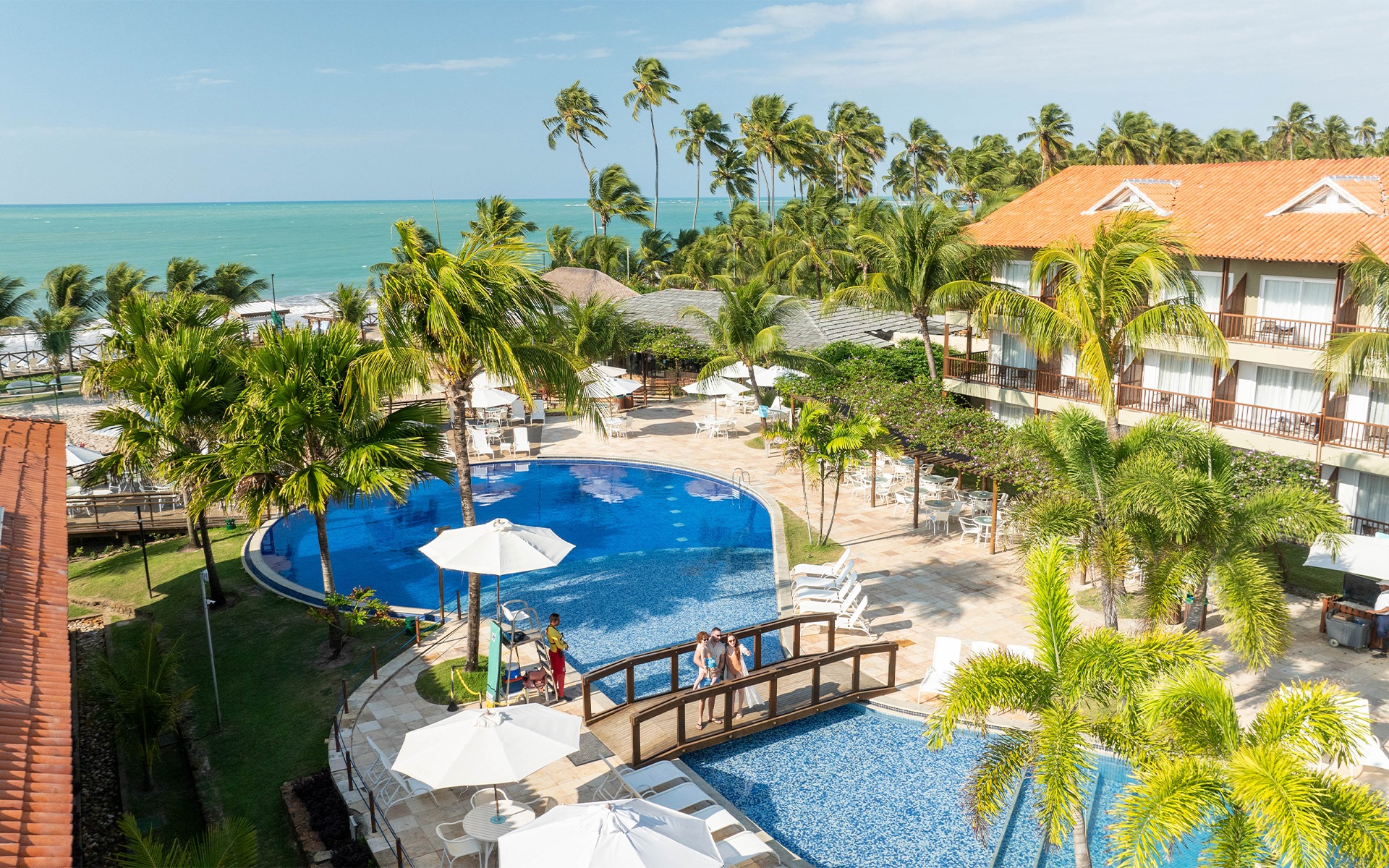 Família sobre ponte da piscina do Salinas Maceió, aprecisando à vista pra piscina principal.