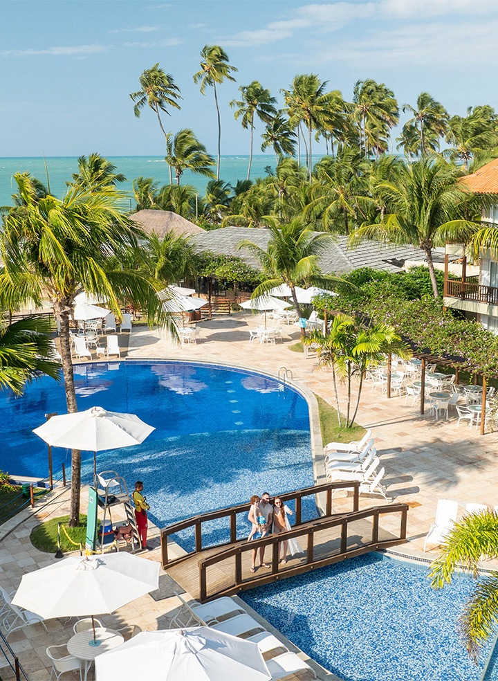 Família sobre ponte da piscina do Salinas Maceió, aprecisando à vista pra piscina principal.