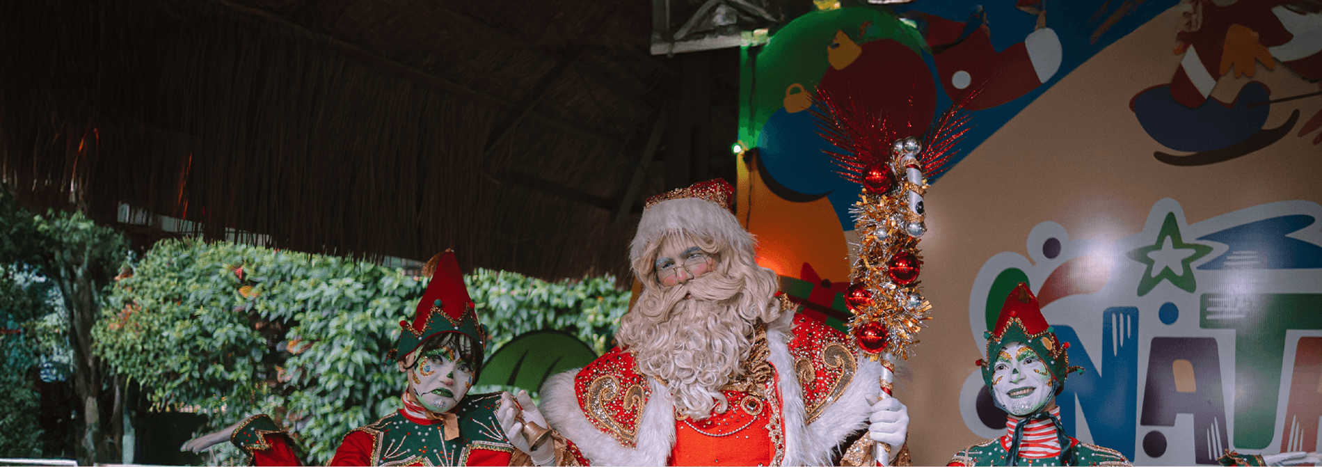 Papei noel e dois duendes felizes durante entrega de presentes no natal no Salinas Maceió.