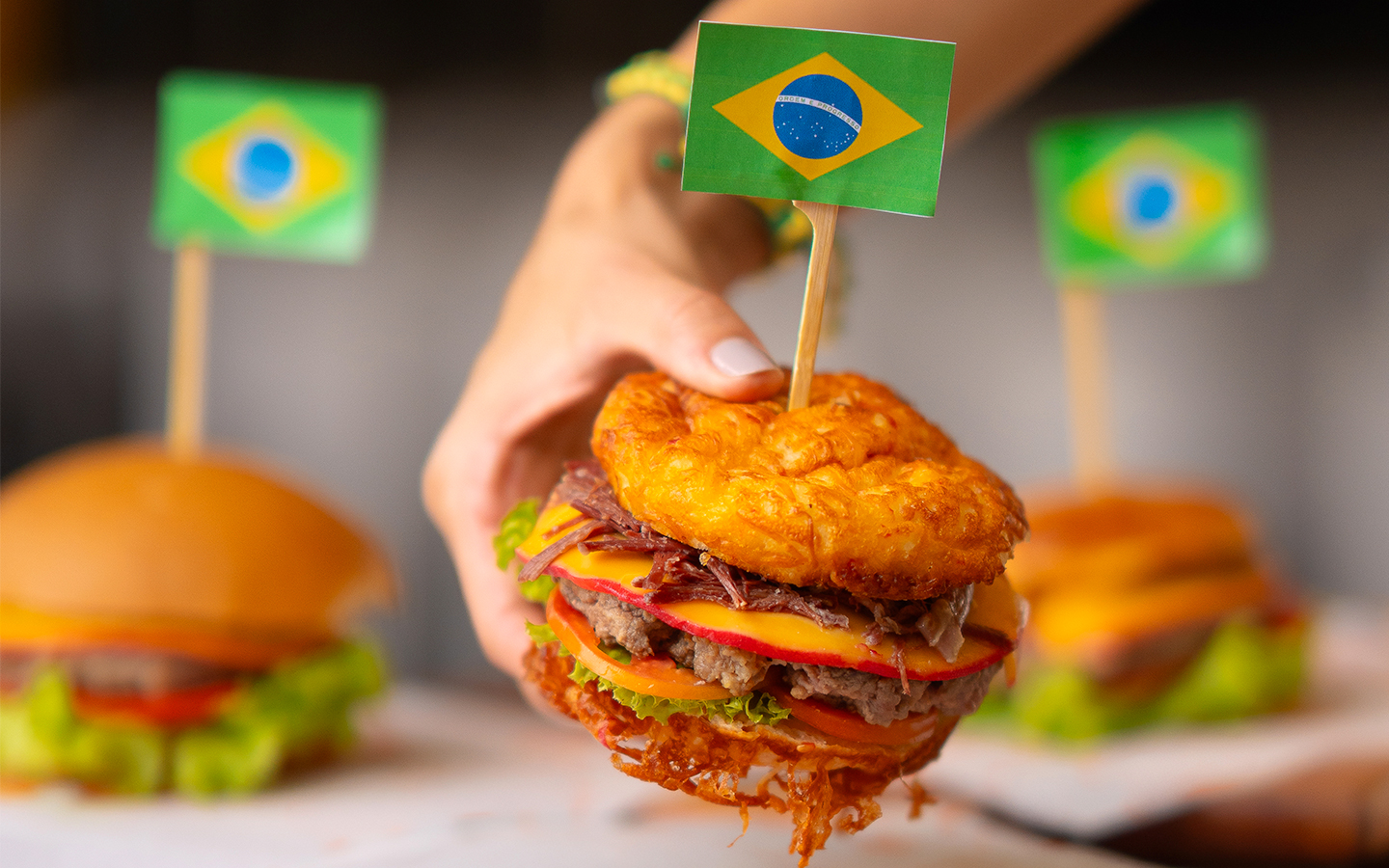 Hambúrguer artesanal com bandeira do Brasil no topo, servido em tábua de madeira no Salinas Maceió.
