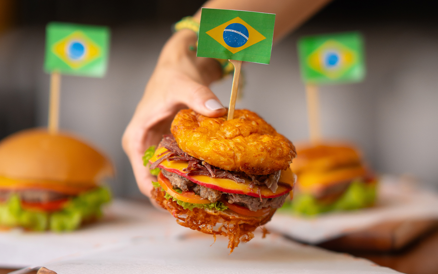 Hambúrguer pra torcida pelo Brasil no Salinas Maceió Hambúrguer artesanal com bandeira do Brasil no topo, servido em tábua de madeira no Salinas Maceió.