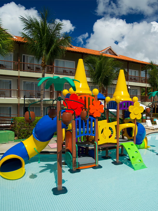 Área infantil aquática do Salinas Maceió com brinquedão pra crianças na piscina, e ao fundo toda a estrutura do resort.