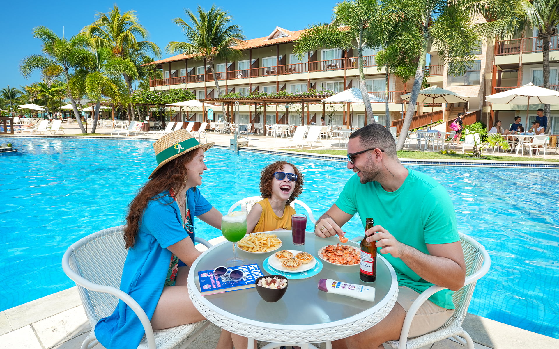 Família aproveitando os petiscos  camarão, batata frita, empada com cerveja, drink e suco na beira da piscina do Salinas Maceió.