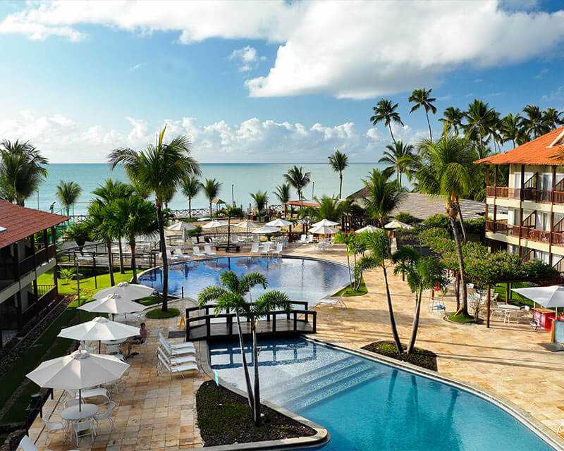 Imagem mostrando a piscina do resort Salinas Maceió com o mar ao fundo.