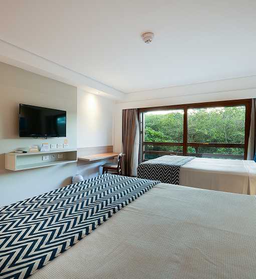 Casal e filho em Ponta de Mangue, o mar está com maré baixa e cristalino, ao fundo os arrecifes de corais.