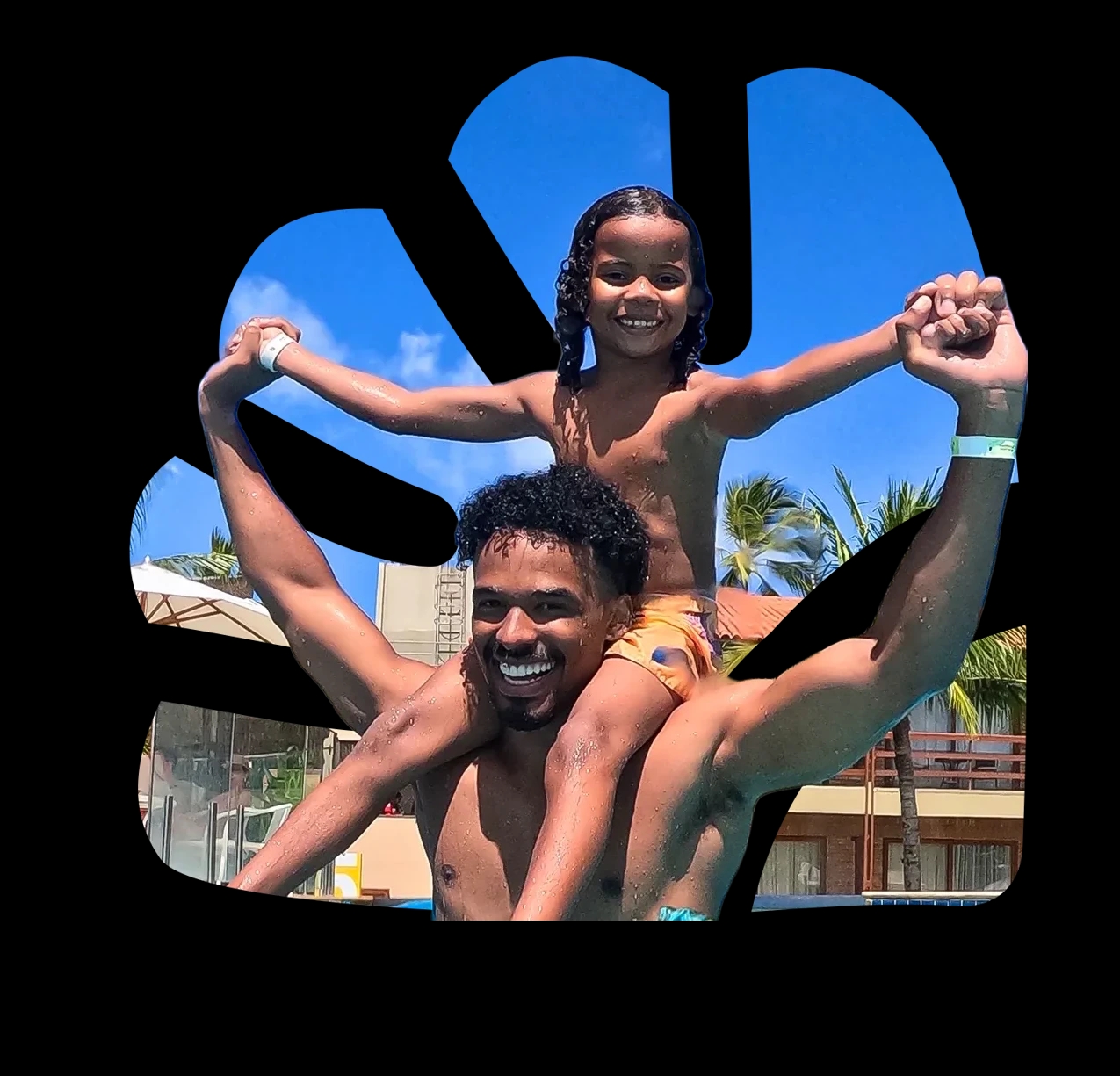 Pai sorridente na piscina do resort com uma criança sentada nos ombros, os dois de mãos dadas e braços abertos. Ao fundo, céu azul, coqueiros e a estrutura do Salinas Maragogi.