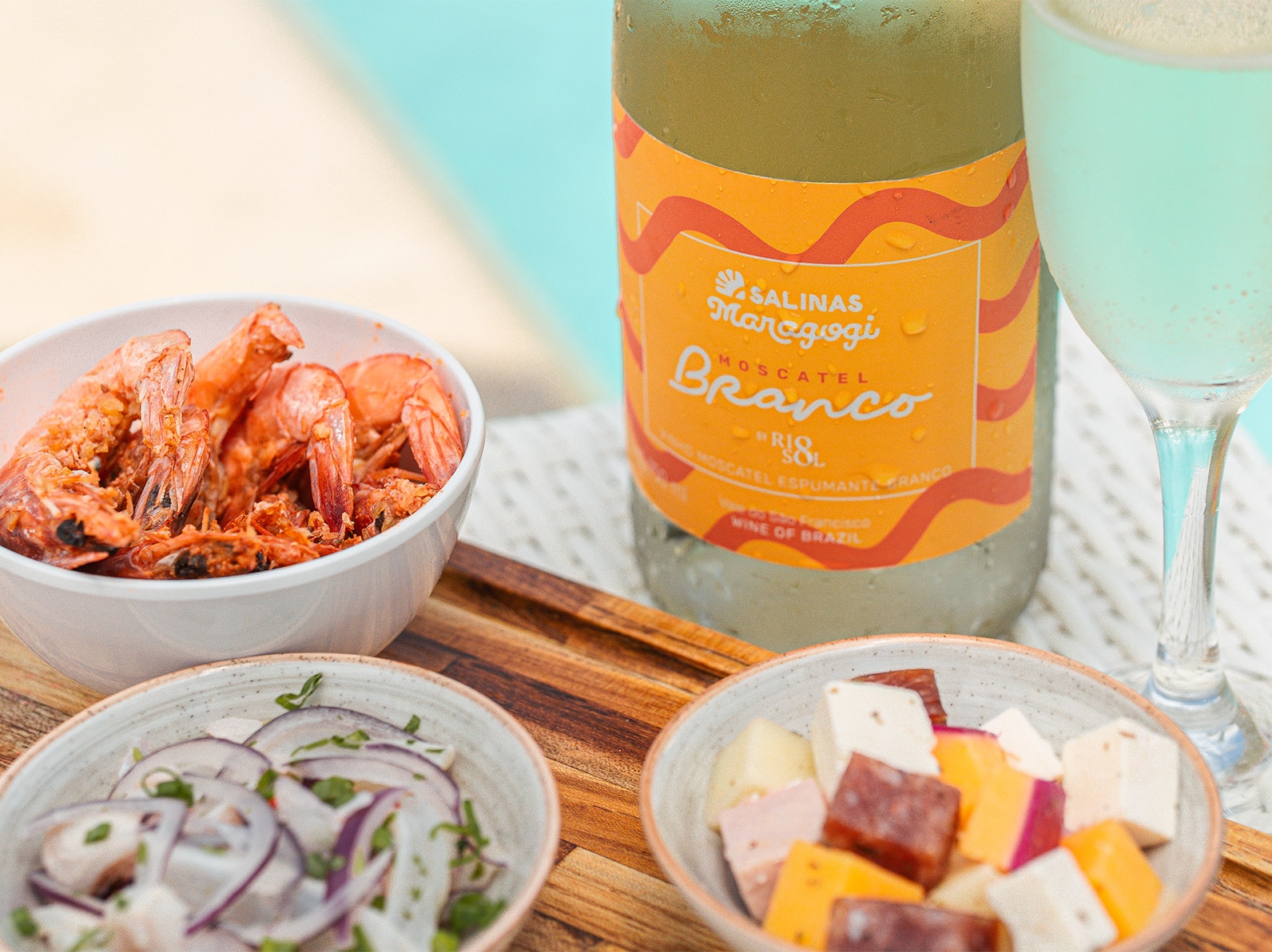 Petiscos com camarão, queijos e cebola roxa acompanhados de espumante Moscatel branco do Salinas Maragogi à beira da piscina.