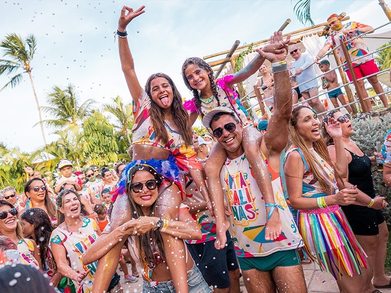 Família usando abadá do bloco Viva Salinas posam pra foto sorrindo.