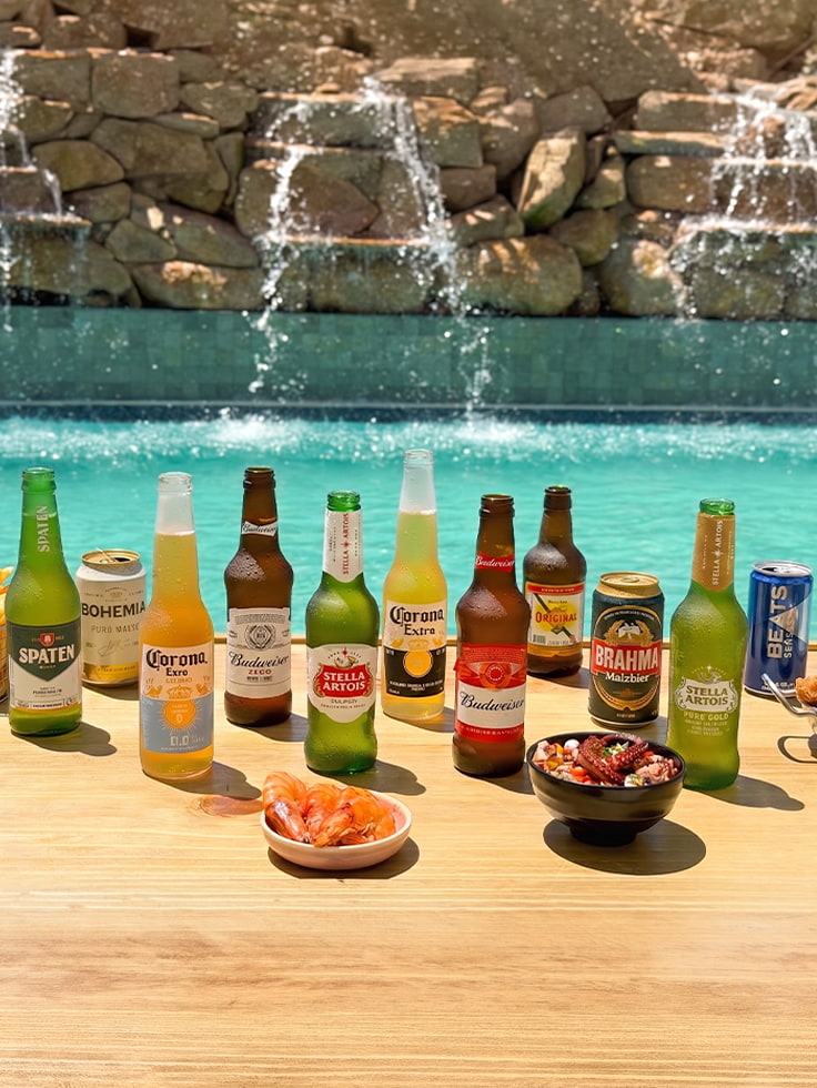 Um brinde às férias e ao ano novo Mesa posta à beira da piscina do Salinas Maragogi com camarões, petiscos e mix de cervejas geladas como Spaten, Corona, Stella Artois, Budweiser e Original.