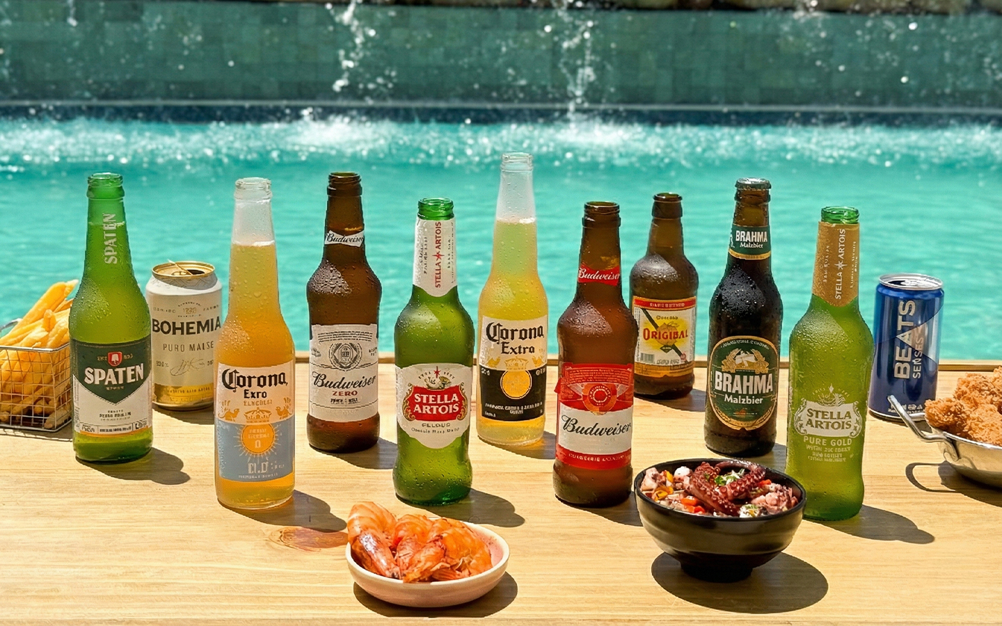 Variedade de cervejas long neck oferecidas no resort All Inclusive Salinas Maragogi, sendo Brahma Malzbier, Corona Extra, Beats, Original, Stella Artois, Bohemia Puro Malte e Budweiser, ao lado de diversas tigelas de petiscos, sendo camarões, batatas fritas.