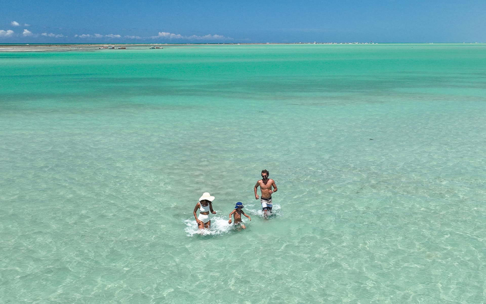 Um marzão de lembranças na Praia de Xaréu Família aproveitando as piscinas naturais da Praia de Xaréu durante passeio com águas azuis e cristalinas.