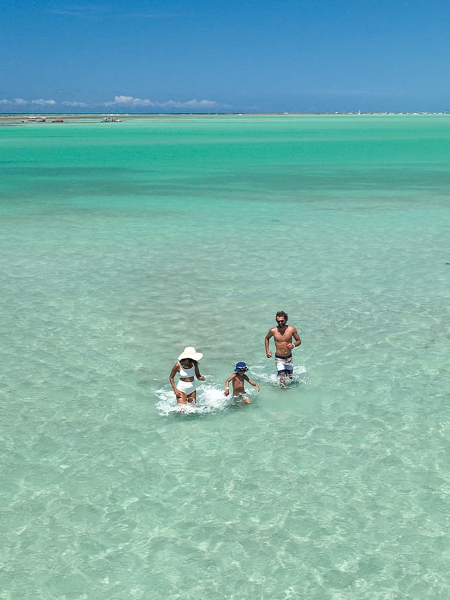 Um marzão de lembranças na Praia de Xaréu Família aproveitando as piscinas naturais da Praia de Xaréu durante passeio com águas azuis e cristalinas.