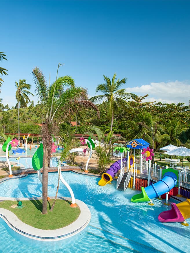 Diversão pra todas as idades Área infantil aquática do Salinas Maragogi com brinquedos pra crianças e cercados por coqueiros.