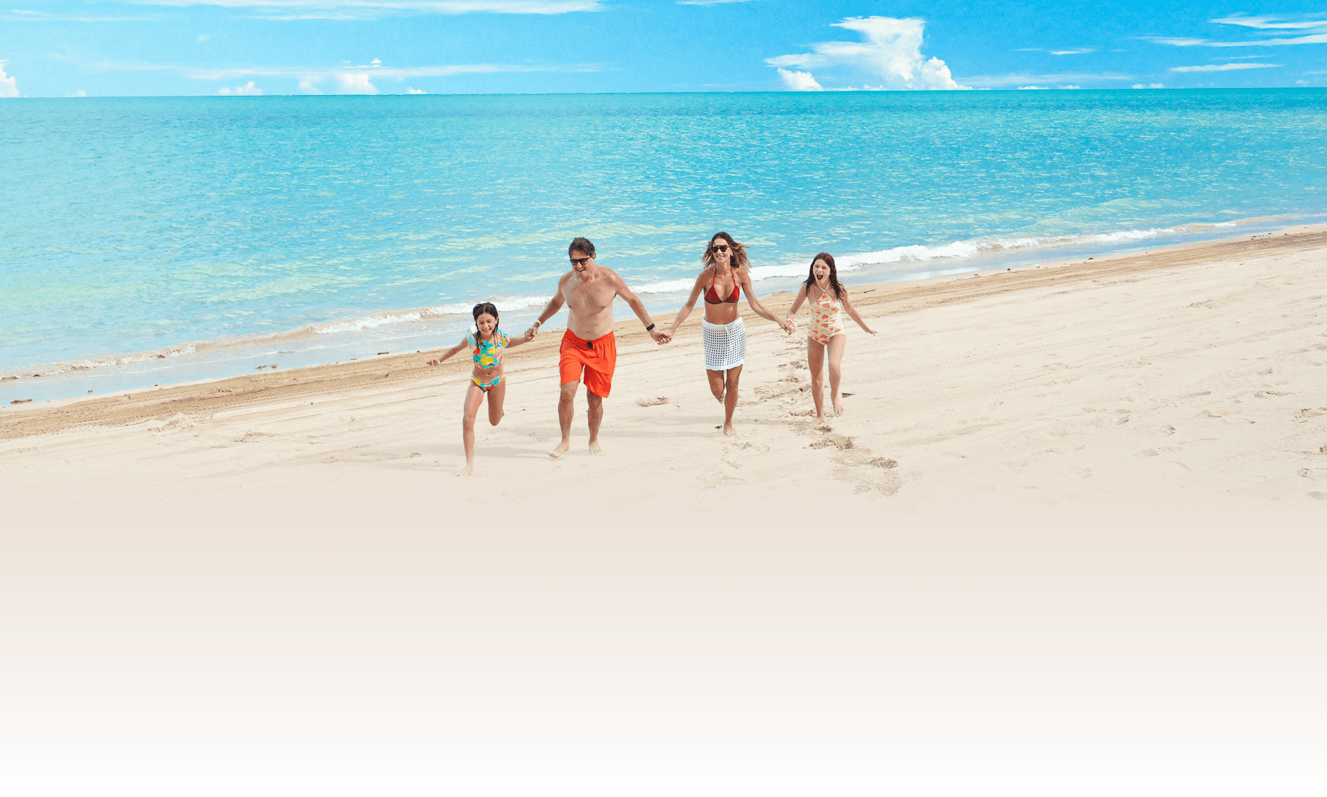 Família feliz aproveita caminhada tranquila na beira mar da praia de Maragogi, próximo ao resort Salinas.