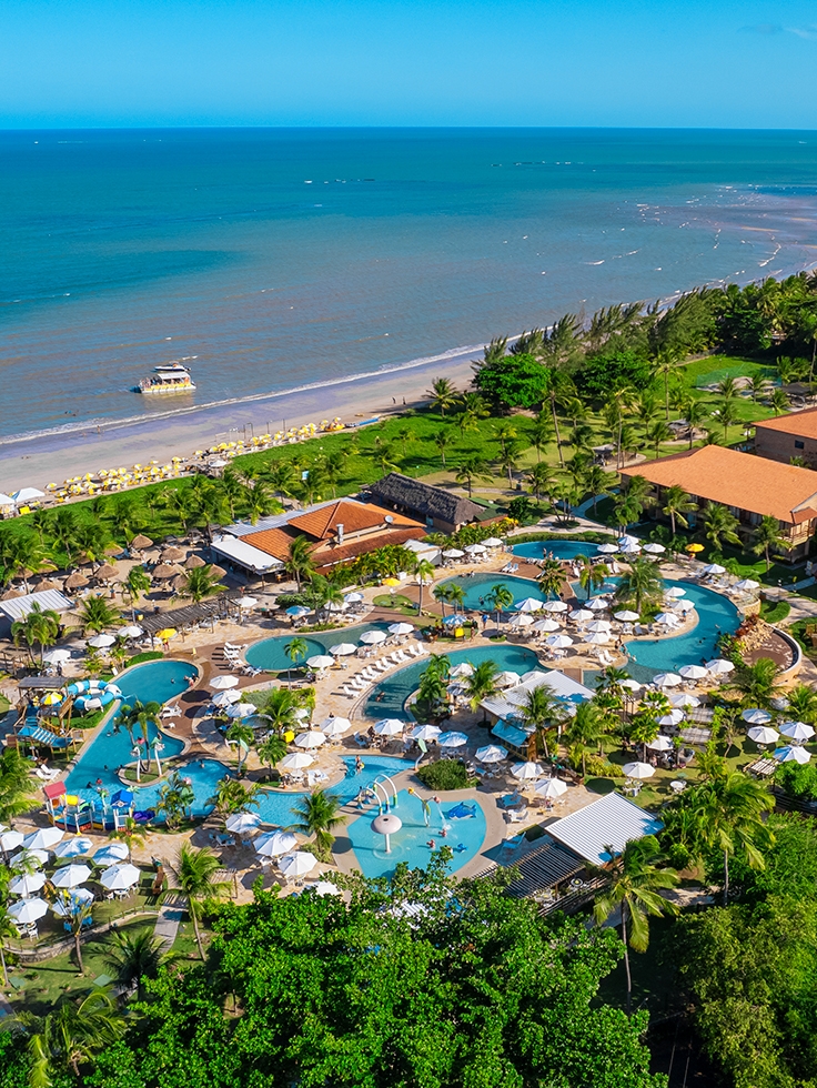 vista-aerea-salinas-maragogi Imagem aérea do Salinas Maragogi mostrando o complexo de piscinas, dos quartos, pontos de consumo e ao fundo a praia. Área verde cercando todo o resort.