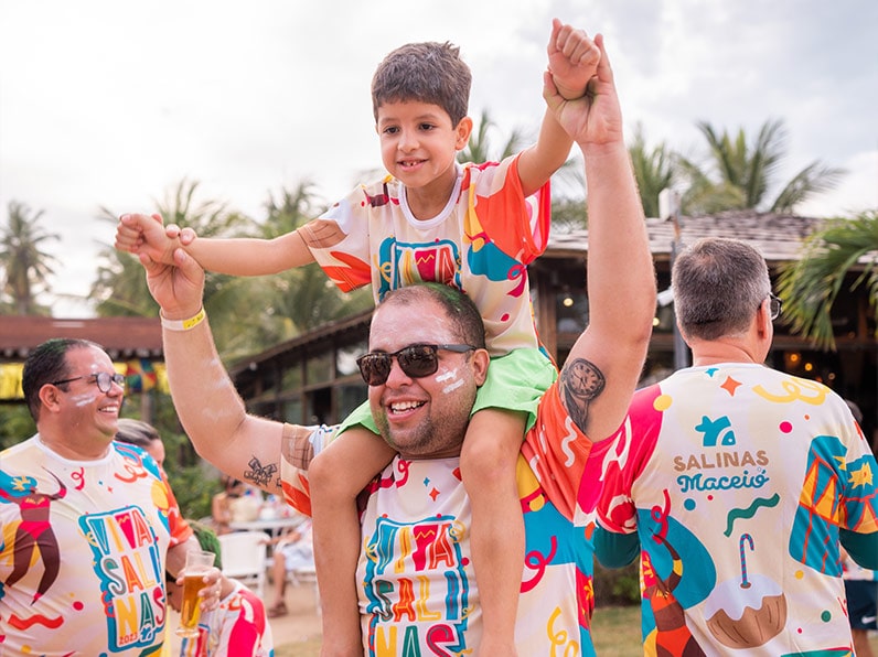 Pai carrega filho nos ombros durante o bloco Viva Salinas.