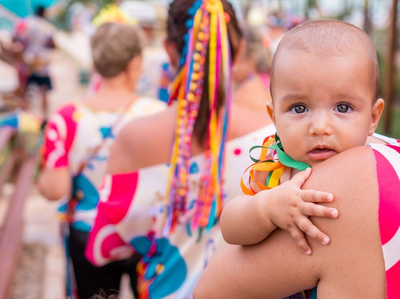 Bebê de colo enfeitada com fitinhas nas cores do bloco Viva Salinas.