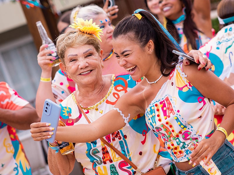 Mulheres vestidas com abadá do Carnaval Salinas Maceió posam pra foto